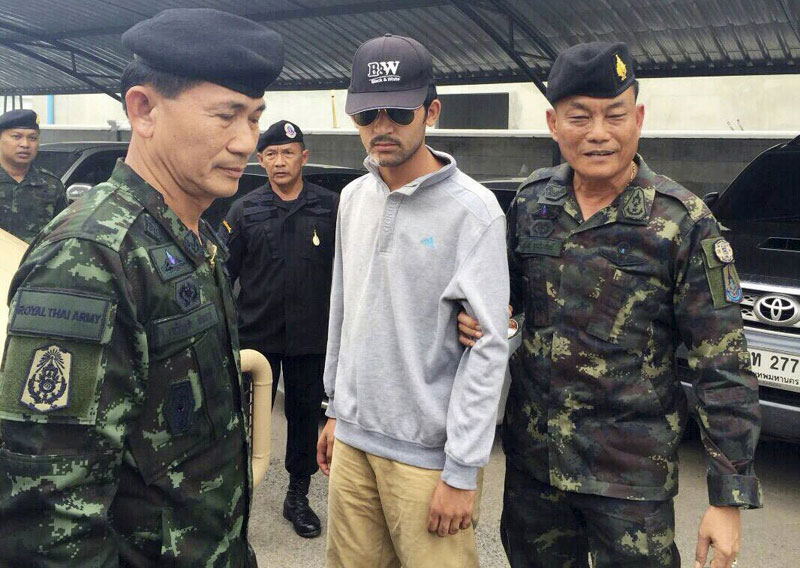 Thai army officers walk with a suspect, believed to be involved in the August bombing that killed 20 people in Bangkok, after his arrest near the Thai-Cambodian border in this handout picture released Tuesday. (Reuters)