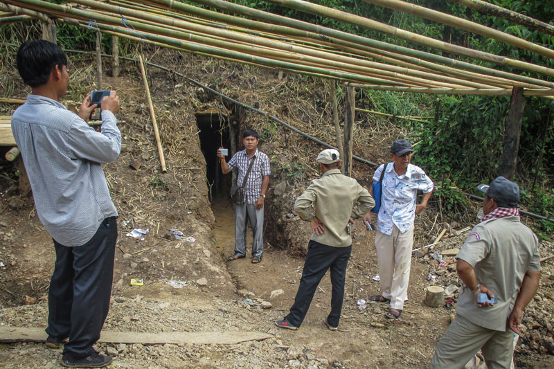 Adhoc coordinator Chhay Thy, second from left, stands by an illegal gold mine in Ratanakkiri province that was raided by police Thursday. (Adhoc)