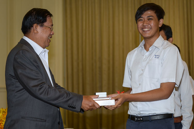 Prime Minister Hun Sen congratulates a student who earned an A on the national high school exam at his office building on Tuesday. (Khem Sovannara/Cambodia Daily)