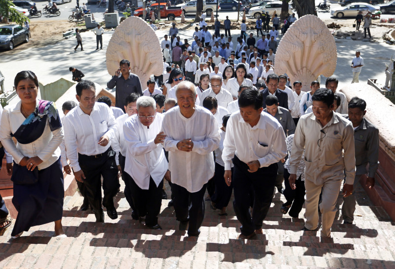 Prince Norodom Ranariddh, center, walks up the steps of Wat Phnom in Phnom Penh on Friday to pray for the success of the royalist Funcinpec party. (Siv Channa/The Cambodia Daily)