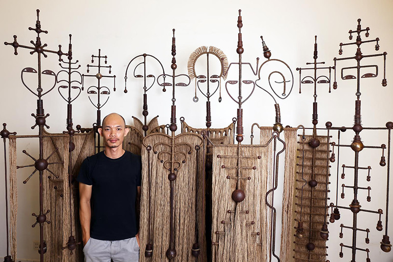 Thang Sothea poses in front of his latest sculpture series, 'Devata.'