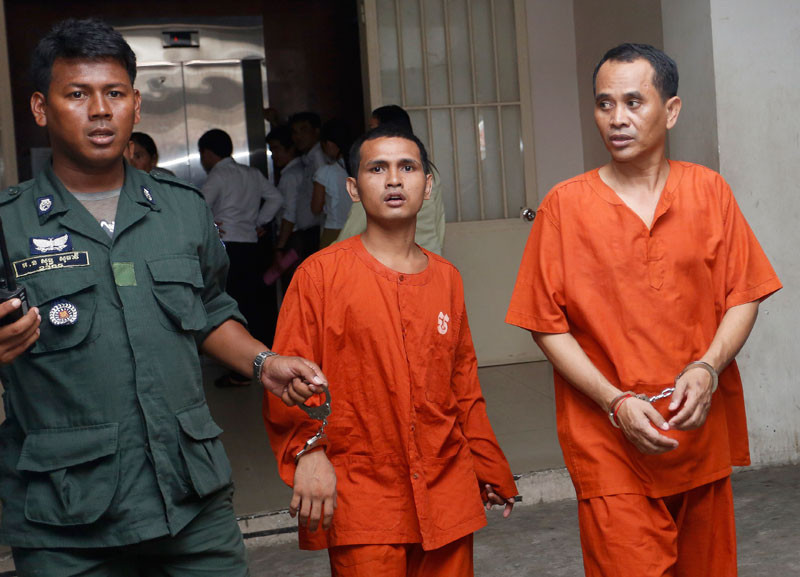 Defense Ministry officer Ouk Sithorn, right, exits the Phnom Penh Municipal Court after being found guilty of fraud for accepting a bribe. (Siv Channa)