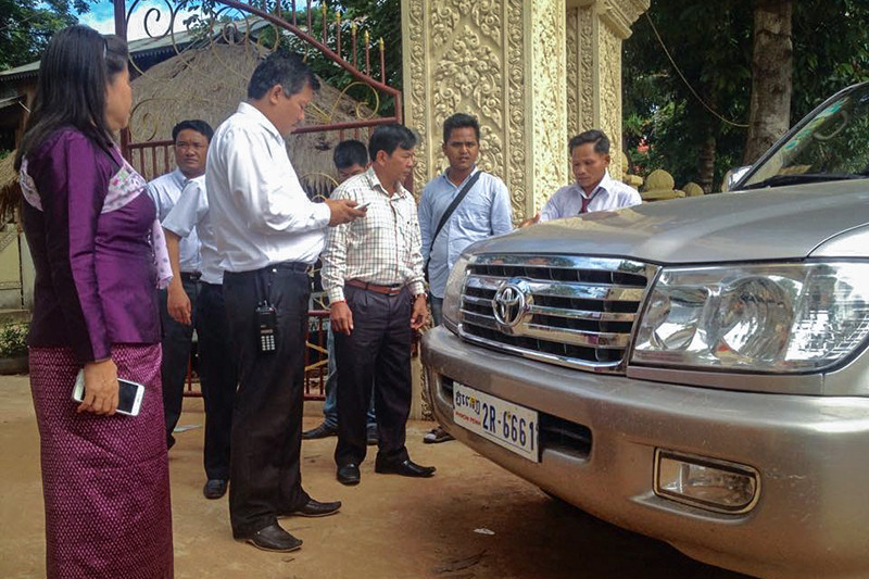 CNRP security chief Long Ry, third from left, stands next to an SUV belonging to the director of the Oddar Meanchey provincial cults and religion department at the entrance to a pagoda in Samraong City yesterday, in a photo posted to the CNRP Radio Facebook page.