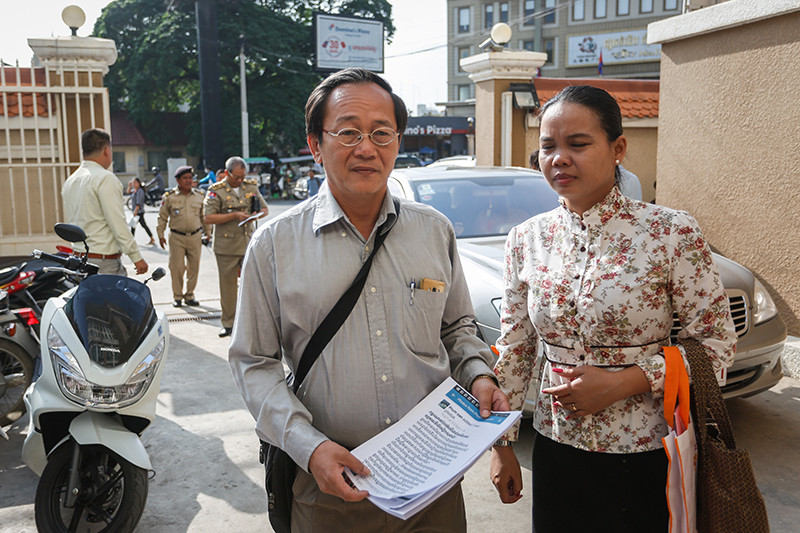 Information Ministry official Prum San, left, enters the Phnom Penh Municipal Court yesterday. (Siv Channa)