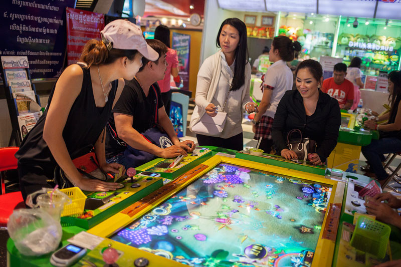 Customers play a fishing game at an arcade in Phnom Penh’s Aeon Mall this week. (Jens Welding Ollgaard/The Cambodia Daily)