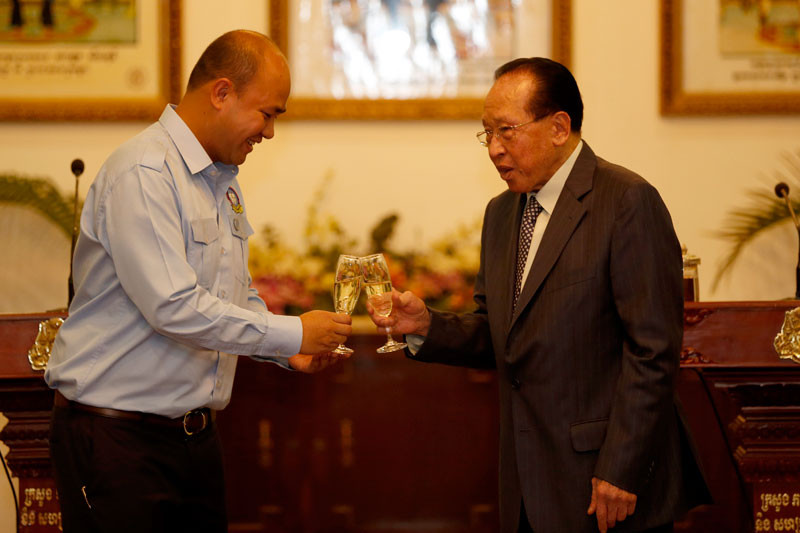 Foreign Affairs Minister Hor Namhong, right, shares a toast with Hun Many, head of the Union of Youth Federations of Cambodia, at a  ceremony at the ministry in Phnom Penh on Monday. (Siv Channa/The Cambodia Daily)