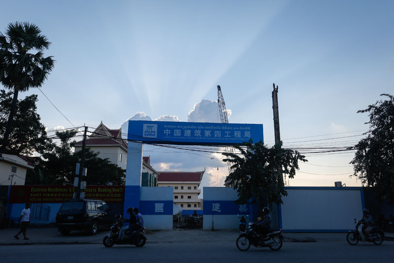 Motorists drive past the Phnom Penh construction site of a Chinese firm that was ordered to stop work on Thursday. (Siv Channa/The Cambodia Daily)