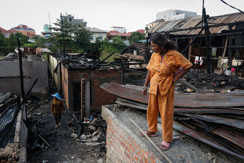 A woman looks at the remains of her Phnom Penh home, which was destroyed in a fire on Tuesday afternoon. Siv Channa/The Cambodia Daily