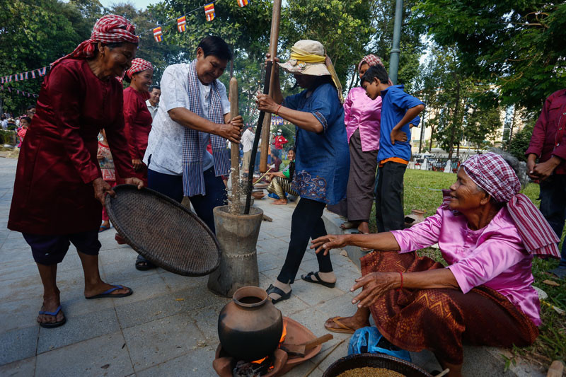 People take turns pounding rice into 'ambok,' a traditional flattened rice snack, at Wat Phnom in Phnom Penh on Wednesday. The ambok-making event was part of this year's Water Festival activities organized by City Hall. (Siv Channa/The Cambodia Daily)