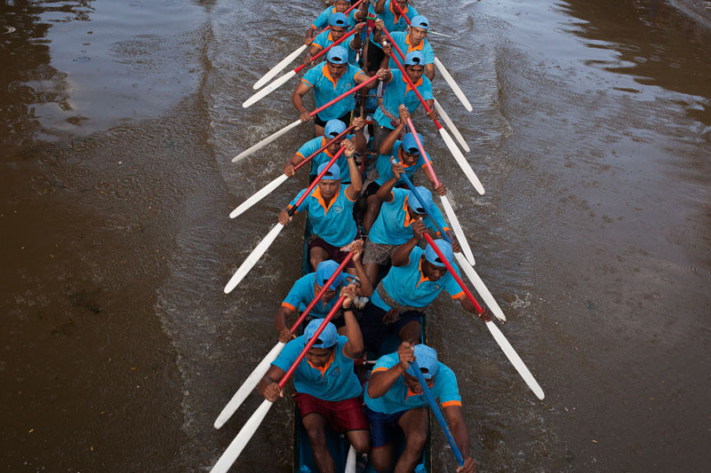 A team paddles their boat down the Siem Reap River on Tuesday on the first day of Water Festival races in Siem Reap City. (Jens Welding Ollgaard/The Cambodia Daily)