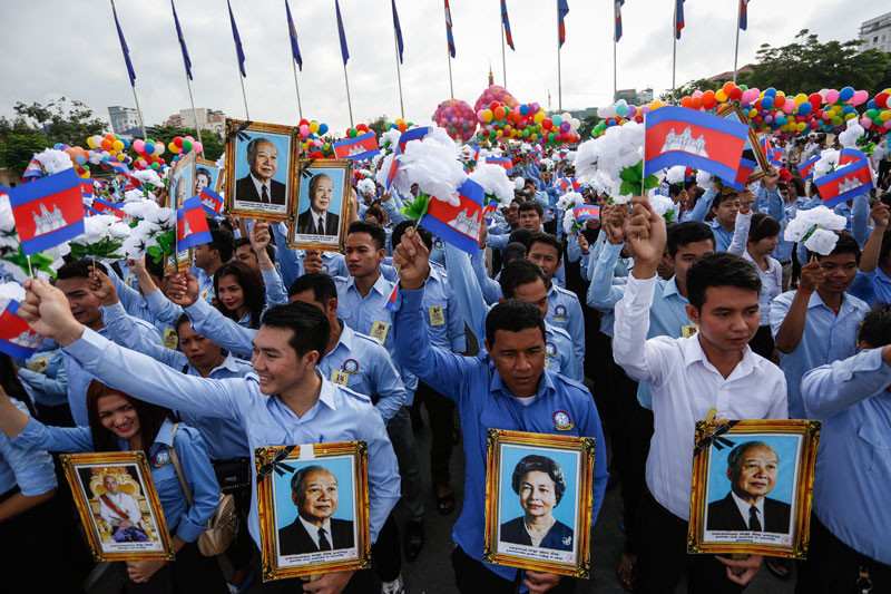 Members of youth groups hold flags, fake flowers and portraits of King Norodom Sihanouk and Queen Mother Norodom Monineath during an Independence Day ceremony in Phnom Penh on Monday. (Siv Channa)