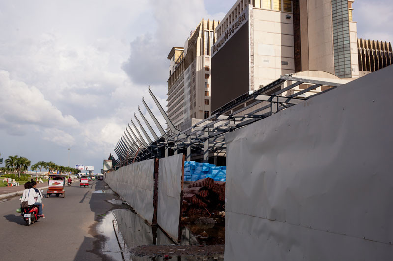 Motorists drive past a construction site that is part of an expansion of NagaWorld casino in Phnom Penh on Sunday. (Jens Welding Ollgaard/The Cambodia Daily)