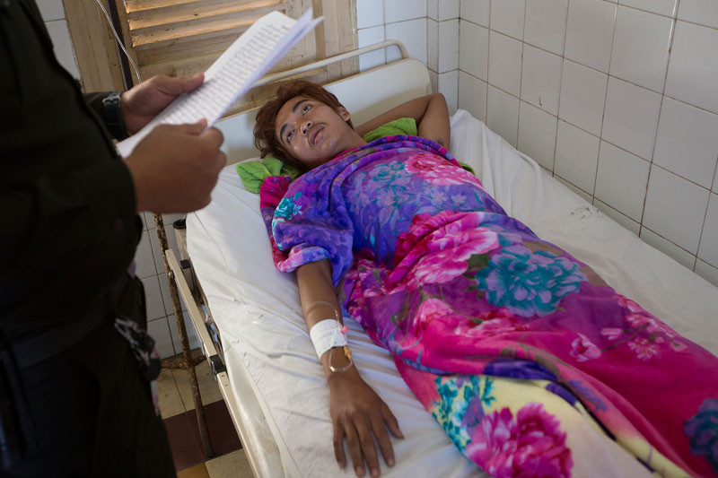 Muong Samnang is interviewed by military police on Thursday at Preah Kossamak Hospital in Phnom Penh. (Olivia Harlow/The Cambodia Daily)