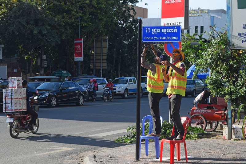 Workers install a new street sign on Norodom Boulevard in Phnom Penh yesterday. (Peter Ford)