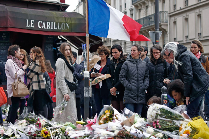 People pay tribute to the victims of the Paris attacks, outside Le Petit Cambodge and Le Carillon on Tuesday. (Reuters)