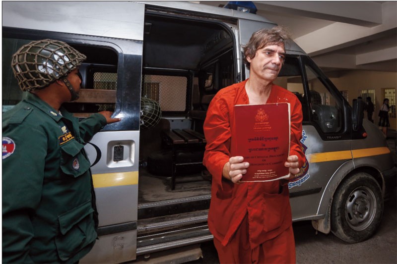 Udo Sabiniewicz displays the Code of Criminal Procedure upon arriving at the Phnom Penh Municipal Court on Thursday. (Siv Channa/The Cambodia Daily)