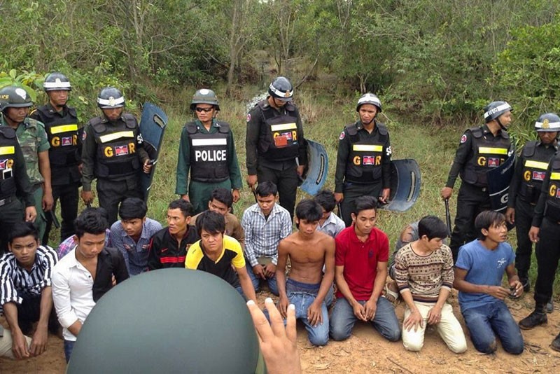 Workers are guarded by military police after being arrested outside the Manhattan SEZ in Bavet City on Monday morning. (Licadho)