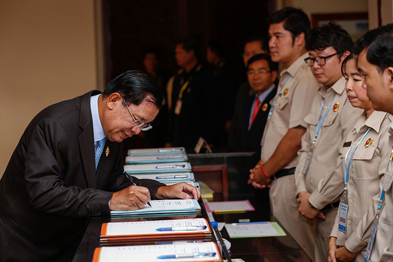Prime Minister Hun Sen signs in at the National Assembly in Phnom Penh on Monday morning. (Siv Channa/The Cambodia Daily)