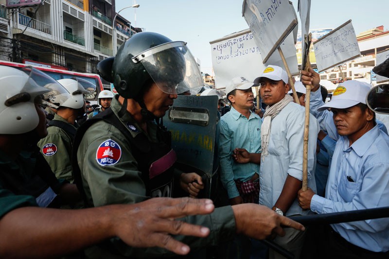 Fired Capitol Tours bus drivers face off with police during a protest in Phnom Penh on Wednesday.