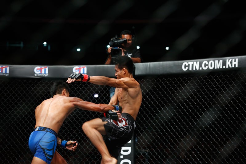 Malaysian Gianni Subba, left, punches Thai Anatpong Bunrad on his way to victory in their fight at Koh Pich Theater in Phnom Penh on Saturday. (Siv Channa/The Cambodia Daily)