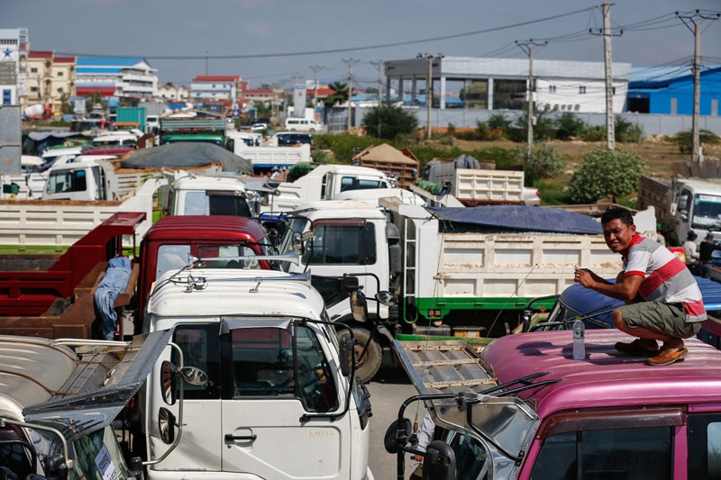 Cargo trucks block National Road 3 in Phnom Penh on Wednesday morning in a protest by their owners against the government's order that the illegal right-hand-drive vehicles be taxed and modified. (Siv Channa/The Cambodia Daily)