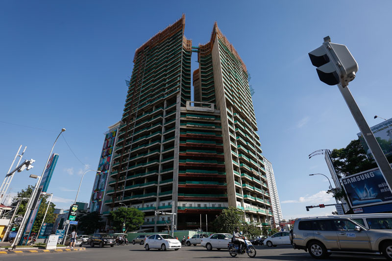 Motorists drive past Gold Tower 42 in Phnom Penh on Tuesday. (Siv Channa/The Cambodia Daily)