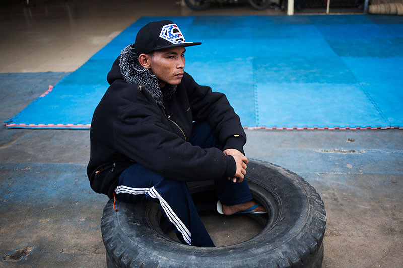 Dun Sam Ang sits in a tire at Old Stadium. (Jens Welding Ollgaard/The Cambodia Daily)
