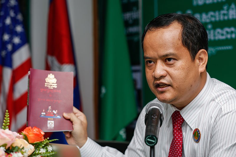Siv Channa/The Cambodia Daily Khmer Power Party President Sourn Serey Ratha holds up a copy of the criminal code during a press conference in Phnom Penh on Friday.