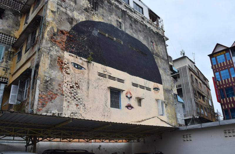 A large painting of a face on the side of an apartment building in Phnom Penh's Daun Penh district on Tuesday. (Peter Ford/The Cambodia Daily)