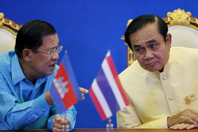Prime Minister Hun Sen, left, speaks to his Thai counterpart, Prayuth Chan-ocha, during a signing ceremony at the Government House in Bangkok on Saturday. (Reuters)