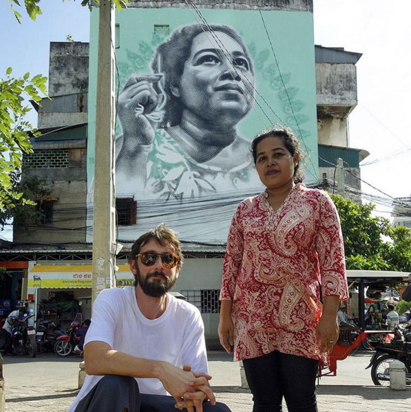 Moeun Thary, right, stands next to Miles 'El Mac' MacGregor in front of Mr MacGregor's mural of her face on Phnom Penh's White Building in a photograph posted to David Choe's Instagram account last week.