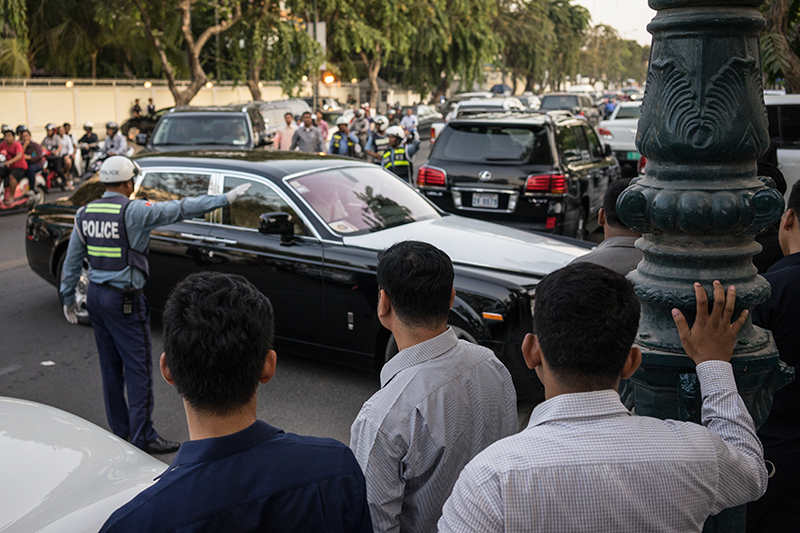 A traffic police officer directs a Rolls-Royce in front of Mr. Sar Kheng’s mansion. (Ben Woods/The Cambodia Daily)