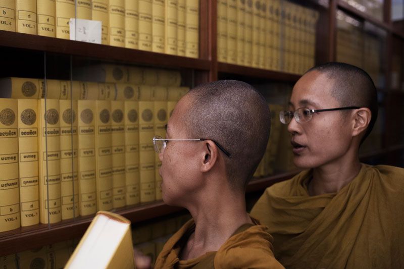Bhikkhunis browse through Buddhist texts at the temple. (Jens Welding Ollgaard/The Cambodia Daily)