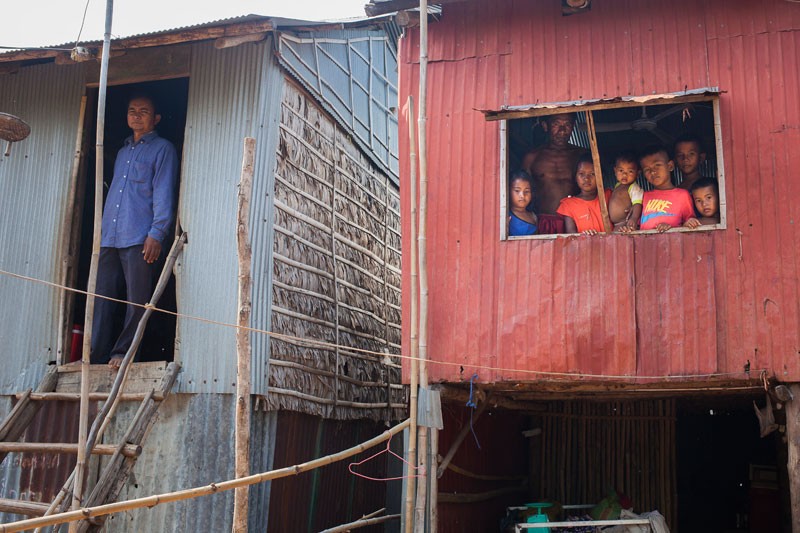 Villagers at the resettlement site in Phnom Bat commune look out of their houses. (Jens Welding Ollgaard/The Cambodia Daily)