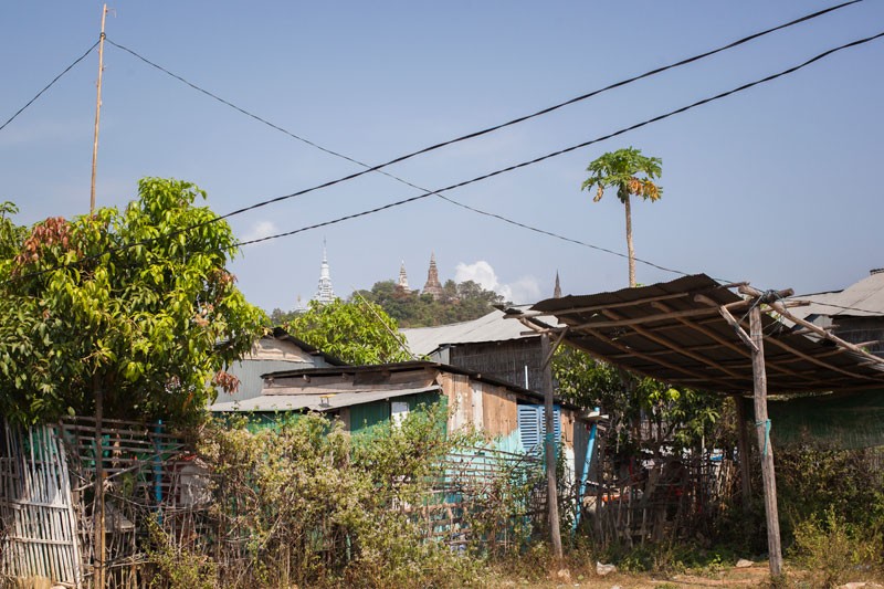 Shrines atop Oudong Mountain can be seen above houses on the resettlement site in Phnom Bat commune. (Jens Welding Ollgaard/The Cambodia Daily)