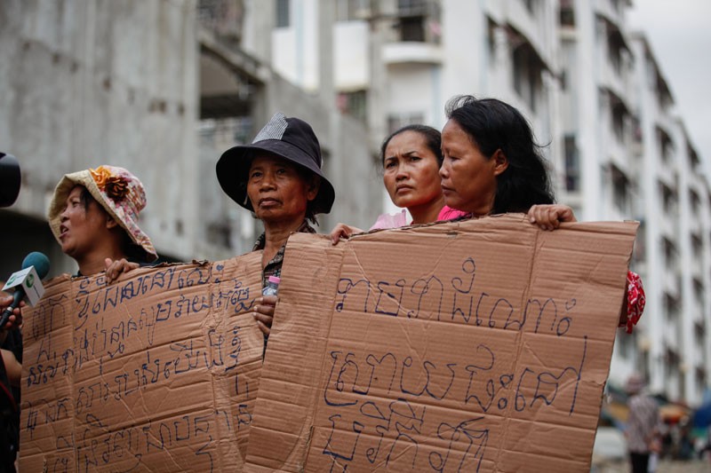 Members of Phnom Penh's Borei Keila community protest near the site of a ceremony to mark final compensation offers for evicted residents on Tuesday. (Siv Channa/The Cambodia Daily)