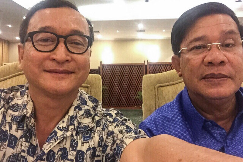 Opposition leader Sam Rainsy, left, takes a selfie with Prime Minister Hun Sen at the Cambodiana Hotel in Phnom Penh in July.