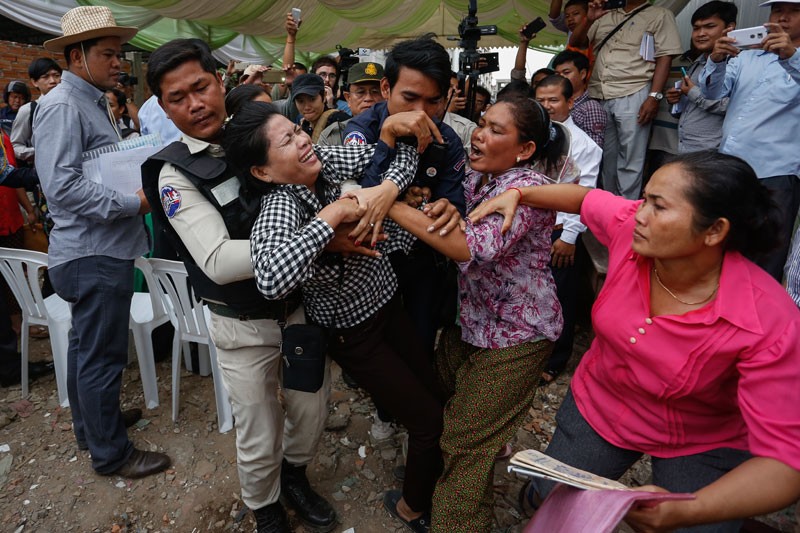 Protester Phork Sophan is dragged from a ceremony held on Tuesday for residents evicted from Phnom Penh's Borei Keila neighborhood. (Siv Channa/The Cambodia Daily)