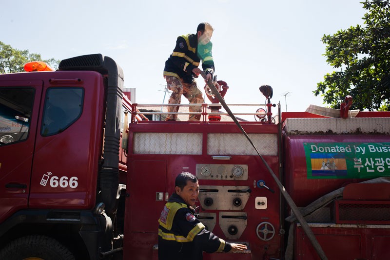 Firefighters put out a blaze at a garage near the Royal Palace in Phnom Penh on Thursday. Two men suffered serious burns in the fire, which was reportedly ignited by a gas leak. ( Jens Welding Ollgaard/The Cambodia Daily)