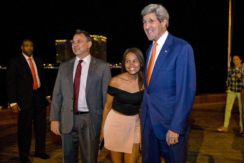 US Secretary of State John Kerry, right, and US Ambassador to Cambodia William Heidt pose for a photograph with a passer-by on the riverside in Phnom Penh on Monday evening. (Reuters) 