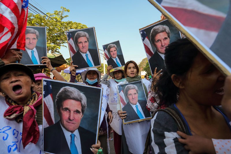 Land rights activists hold photographs of US Secretary of State John Kerry as they march toward the US Embassy in Phnom Penh on Tuesday. (Satoshi Takahashi)