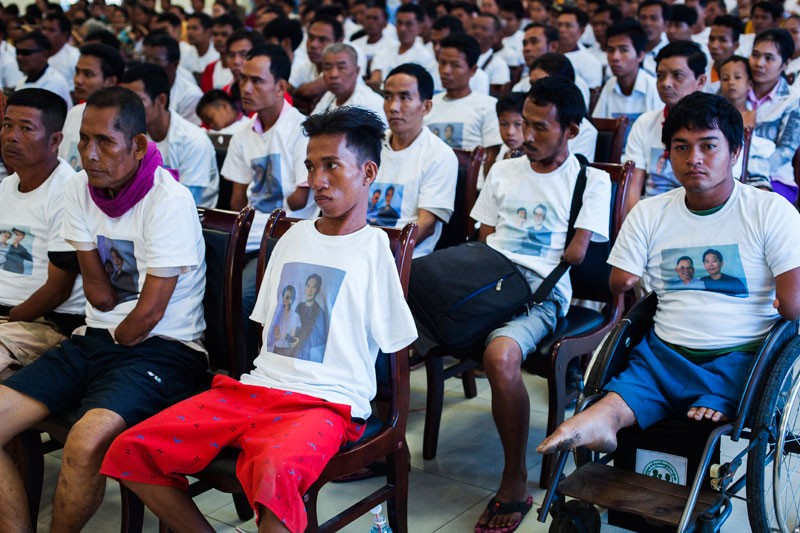 Attendees at an event for Cambodians without hands watch a presentation at the National Institute of Education in Phnom Penh on Sunday. (Jens Welding Ollgaard/The Cambodia Daily) 