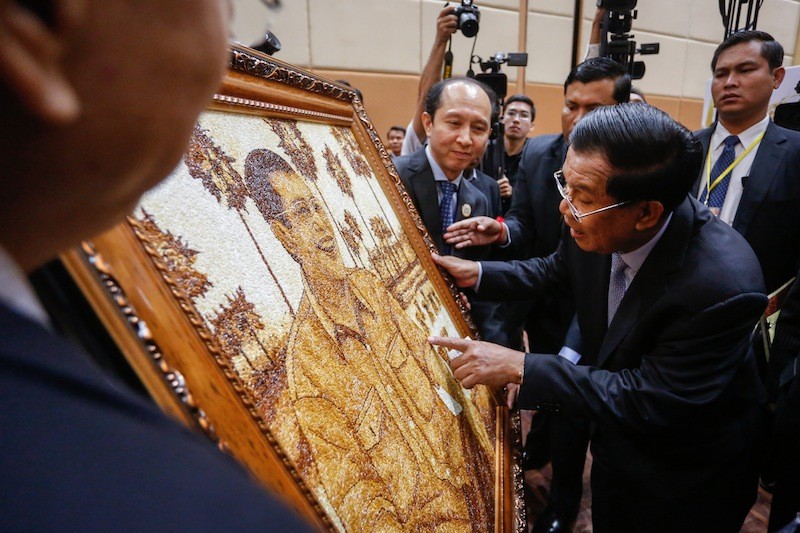 Prime Minister Hun Sen examines a portrait of himself made from rice at the Cambodia Rice Forum in Phnom Penh on Monday. (Siv Channa/The Cambodia Daily)