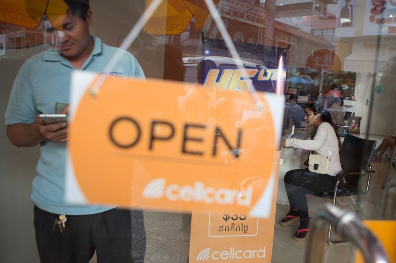 A customer uses his mobile phone inside a Cellcard shop in Phnom Penh last week. (Enric Catala)
