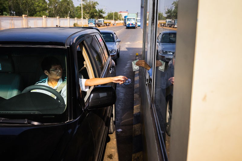 A driver pays a toll on National Road 4 on Wednesday. (Jens Welding Ollgaard/The Cambodia Daily)