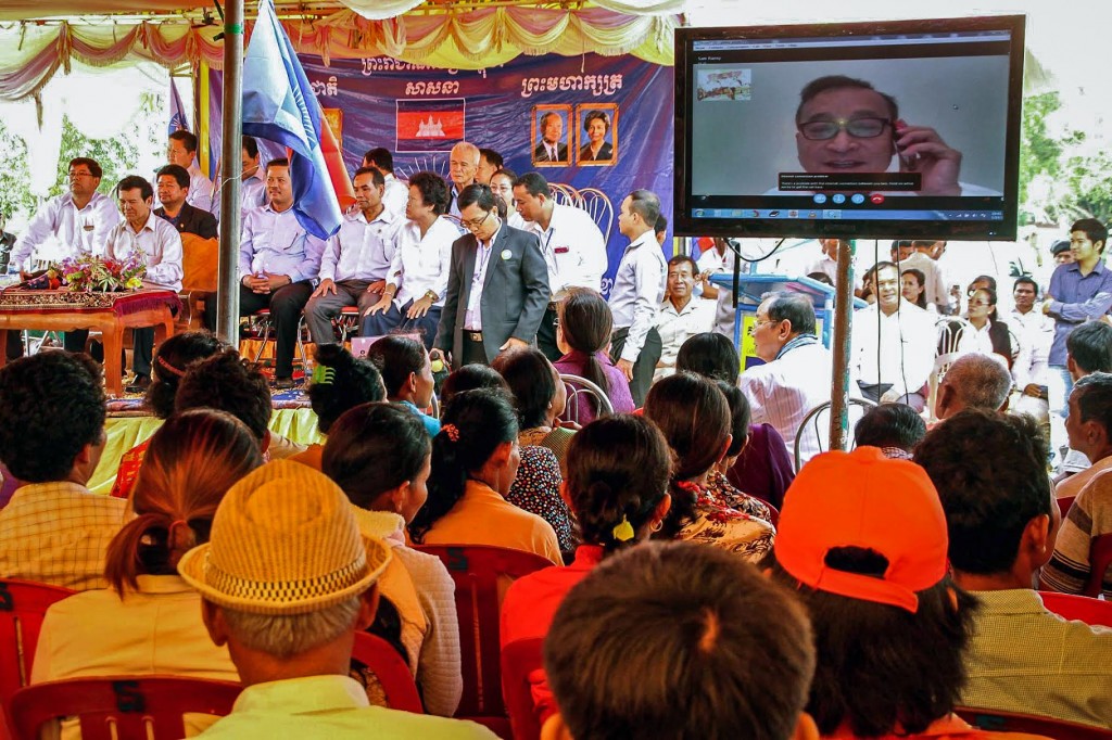 Opposition leader Sam Rainsy talks to supporters via Skype at a public forum on Sunday in Kompong Cham province, in a photograph posted to the Facebook page of his deputy, Kem Sokha. 