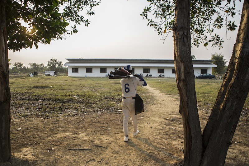 A player carries bats to the team’s dormitory. (Enric Catala)
