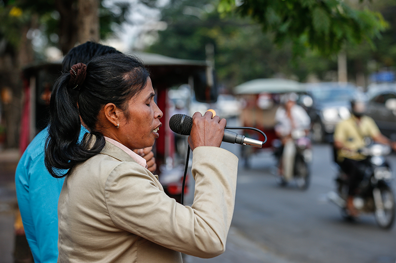 A blind woman sings on Mao Tse Toung Boulevard in Phnom Penh on Friday. (Siv Channa/The Cambodia Daily)