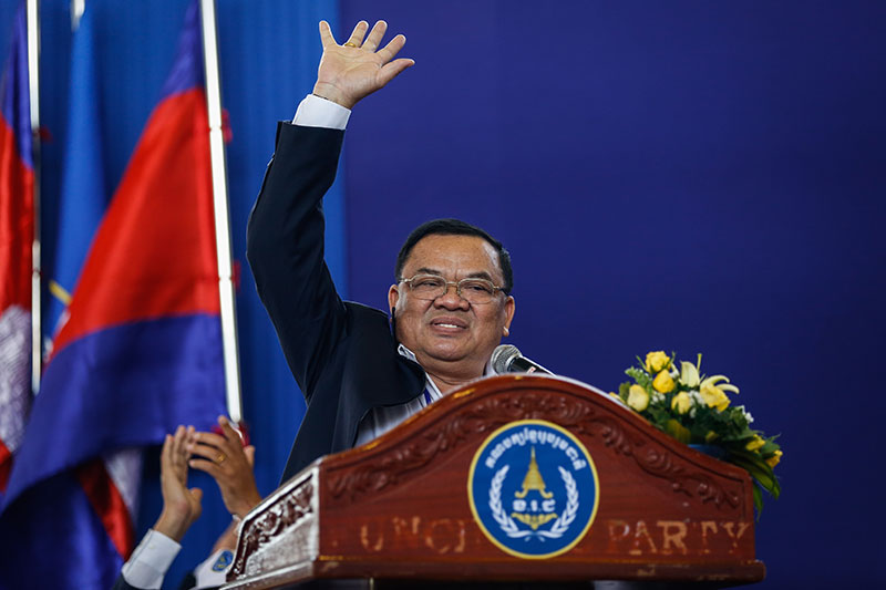 Nhek Bun Chhay addresses members of his Khmer National United Party from behind a repurposed Funcinpec lectern in Phnom Penh on Friday. (Siv Channa/The Cambodia Daily) 