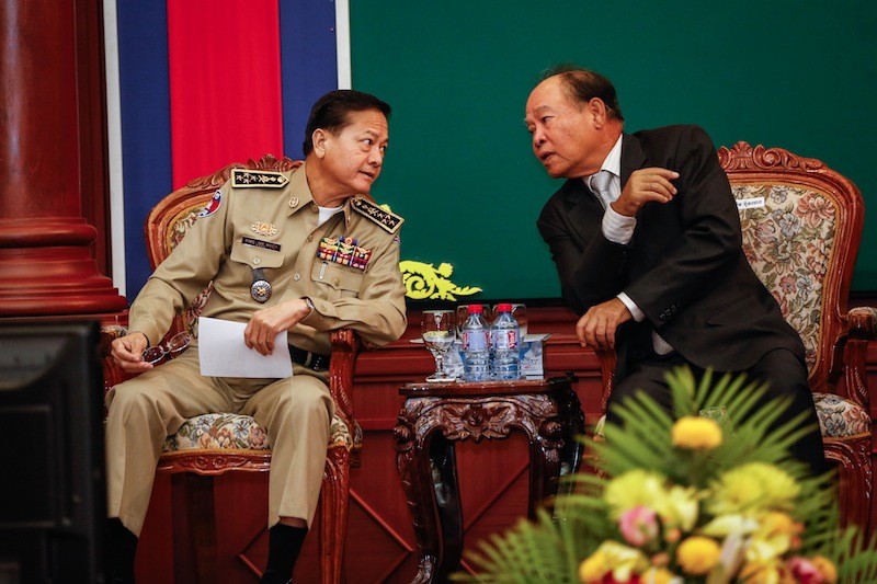 National Police Commissioner Neth Savoeun, left, and Health Minister Mam Bunheng speak during the second day of an annual drug conference at the Interior Ministry in Phnom Penh on Tuesday. (Siv Channa/The Cambodia Daily)